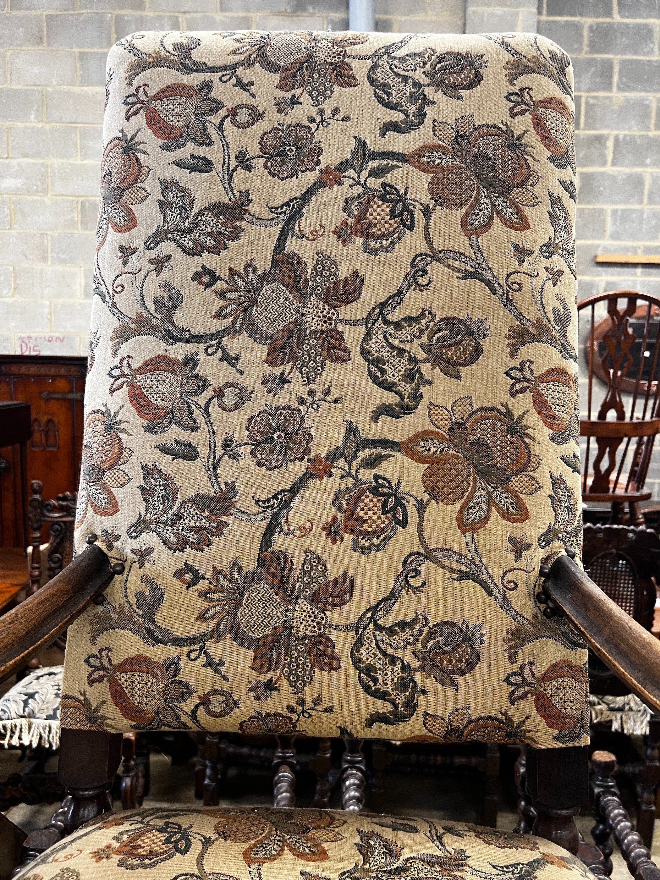 A reproduction Jacobean style mahogany upholstered elbow chair, width 64cm, depth 51cm, height 170cm